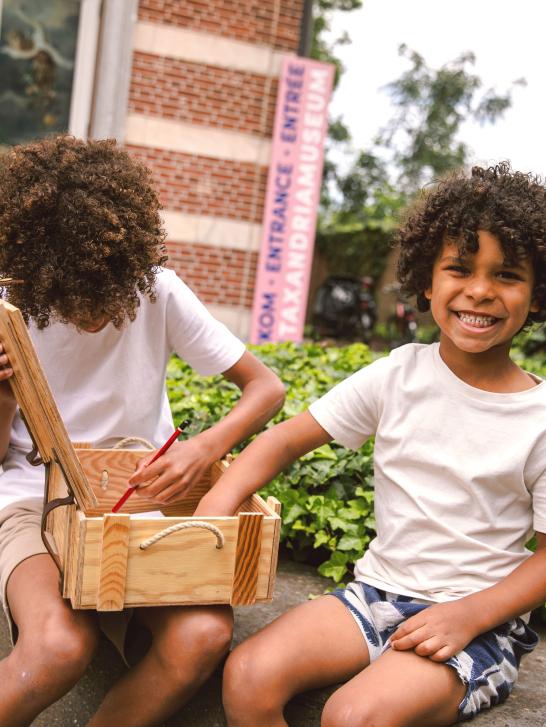Twee kinderen kijken in de schatkist van Vlieg
