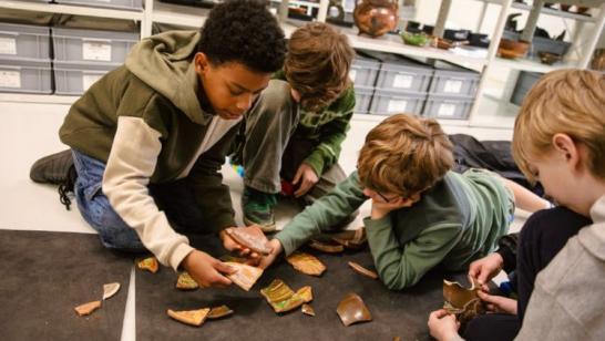 Een groepje kinderen stelt een verzameling scherven samen